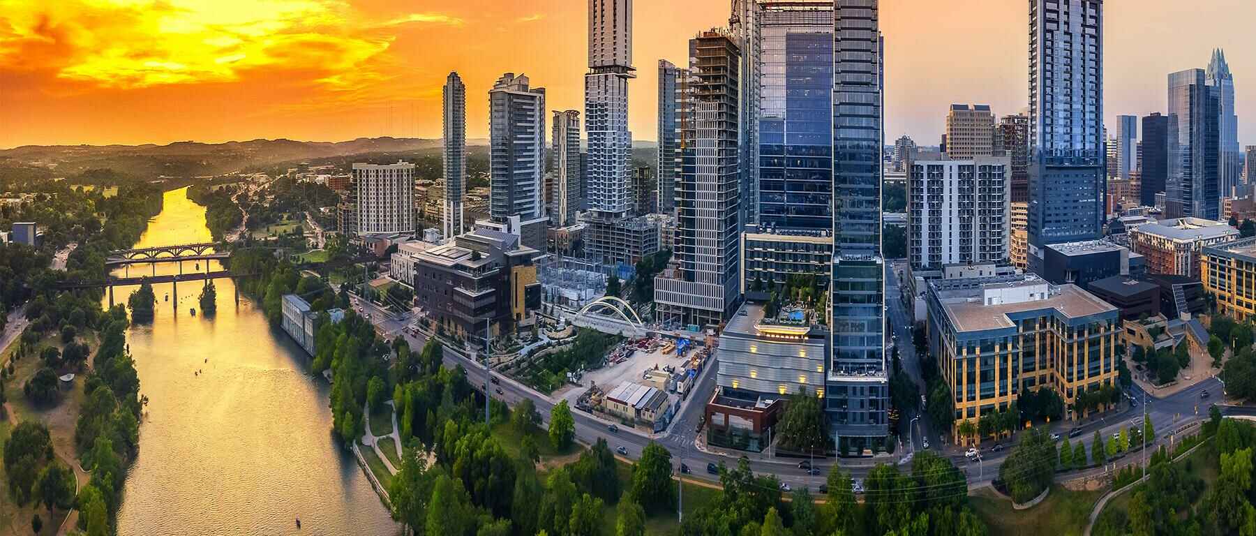Aerial view of Austin, TX downtown skyline with adjacent Colorado River.