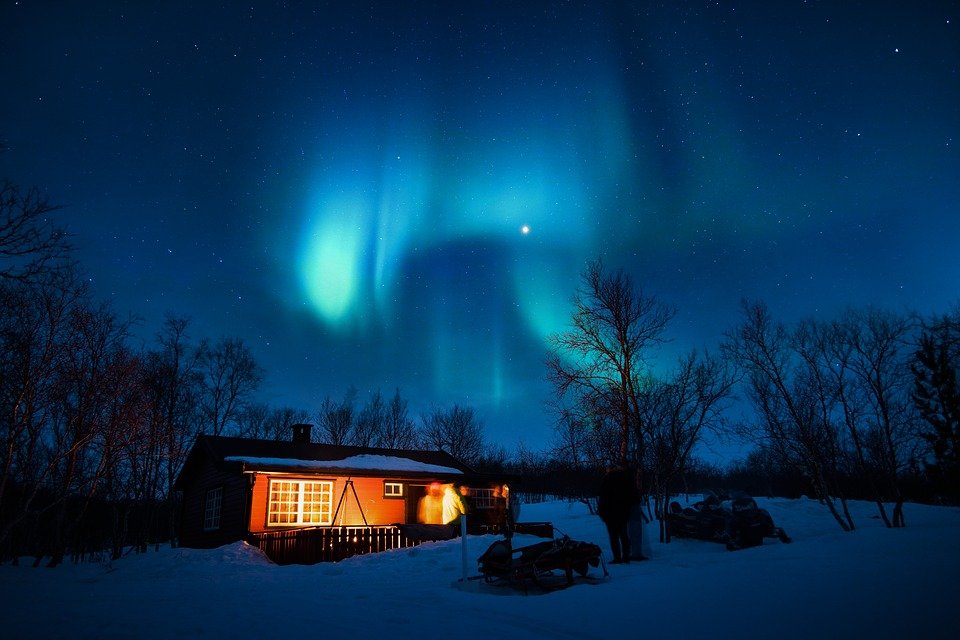 Northern Norway cabin in snow against night sky and northern lights