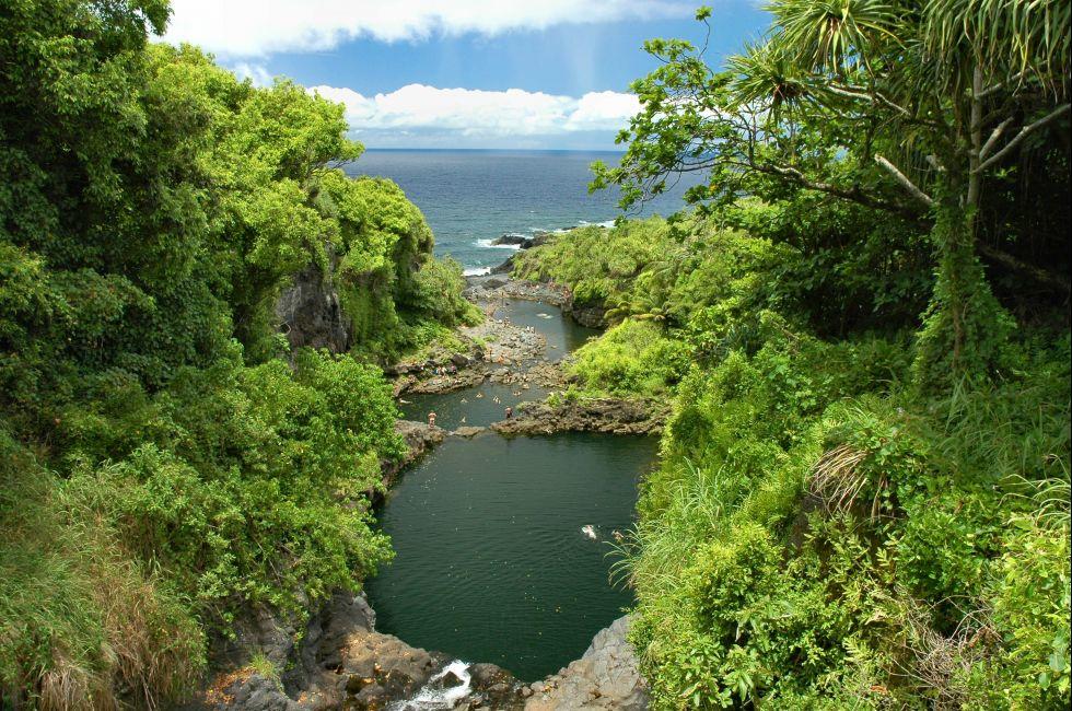 Oheo Gulch East Maui Hawaii met kleine inham die aansluit op de zee met weelderige groene bomen en vegetatie rondom de inham