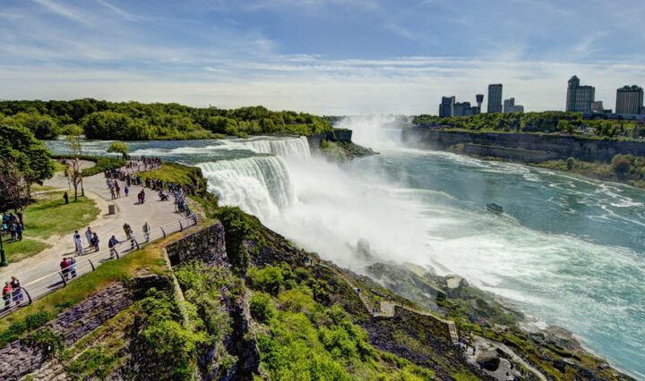 Niagara Falls midt på dagen med Canadas skyline i baggrunden.