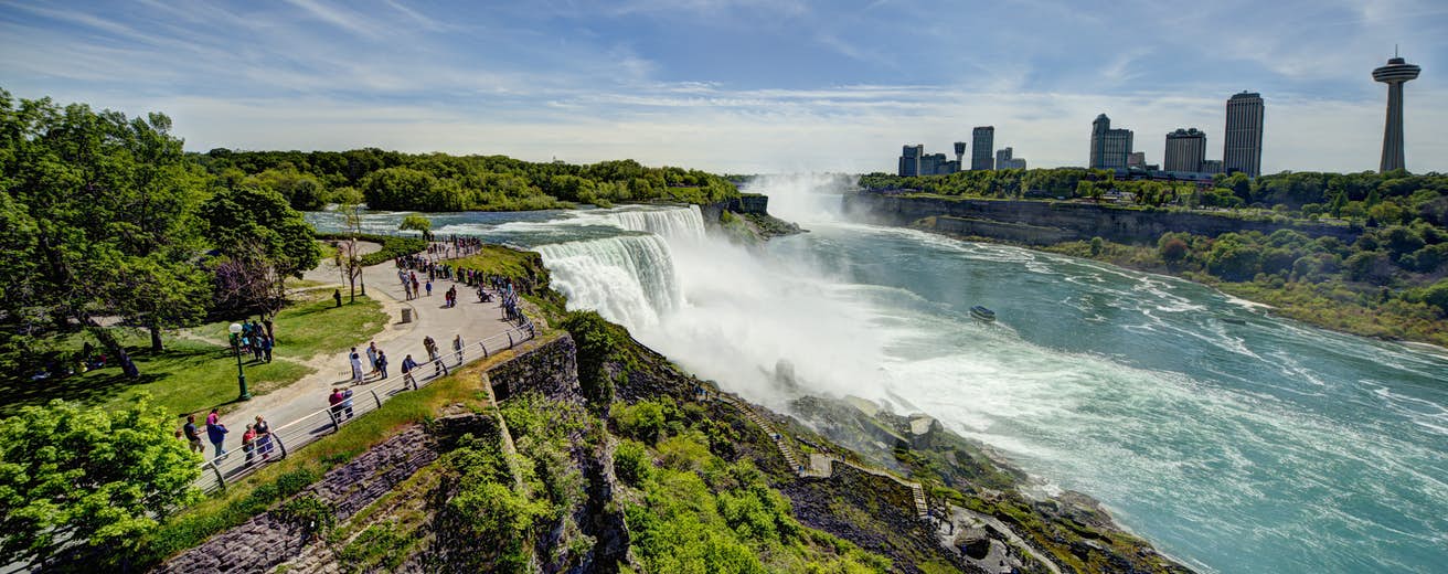 Niagara Falls in the middle of the day with Canada skyline in the background.