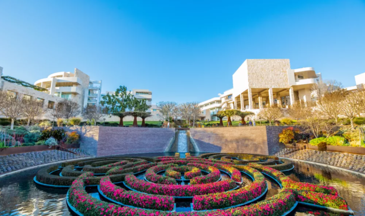 Музей Гети в Лос Анджелис с цветя, подредени в кръг и сграда на заден план.