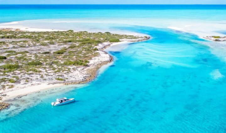 Crystal clear blue lagoon dotted by a lone chartered boat