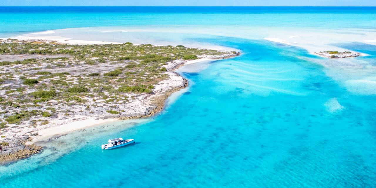 Crystal clear blue lagoon dotted by a lone chartered boat