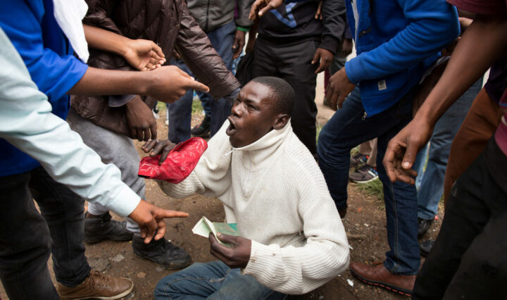 A man holds his South African identity document after being attacked by a mob in Pretoria, South Africa, February 24, 2017. Police fired tear gas, water cannon and rubber bullets to disperse rival marches by hundreds of protesters in Pretoria on Friday, after mobs looted stores this week believed to belong to immigrants.
