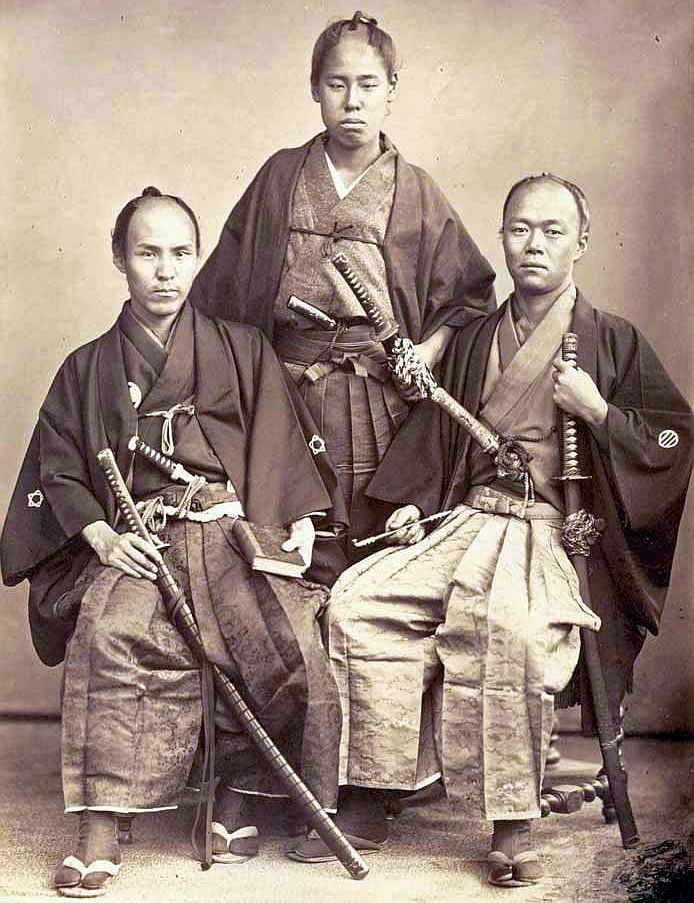 Three Japanese men in everyday Samurai wear, seated for the photograph, showing how they took their appearance to be neat to be examples of feudal Japan.
