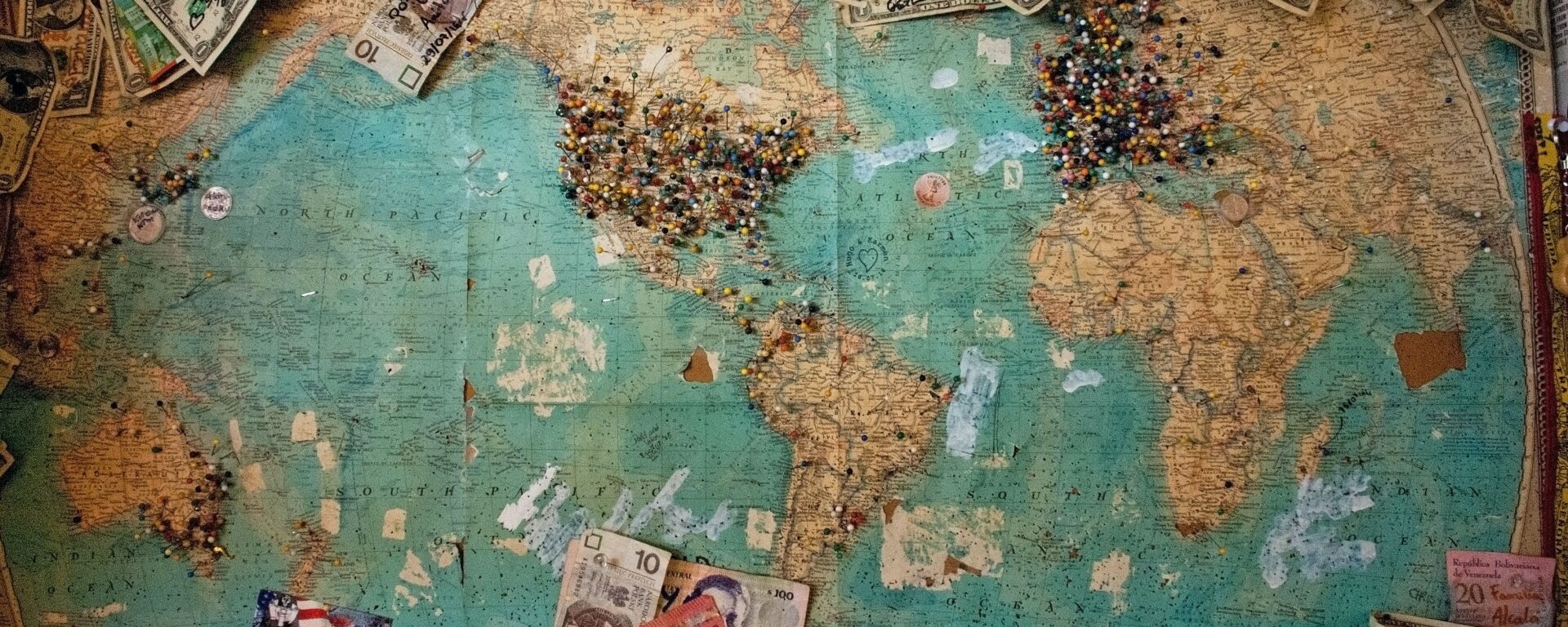Picture of a world map with money of differnt currencies around it.