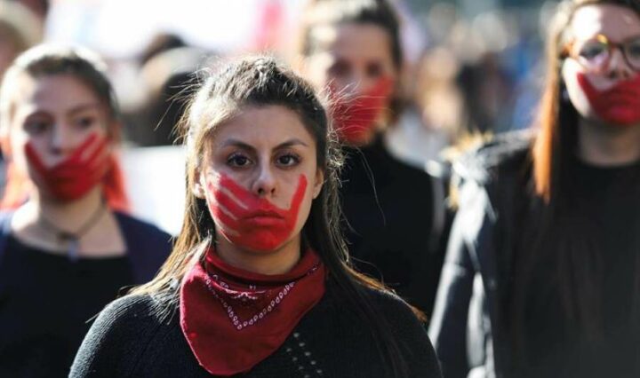 Kvinder i Latinamerika protesterer med røde håndtryk i ansigtet
