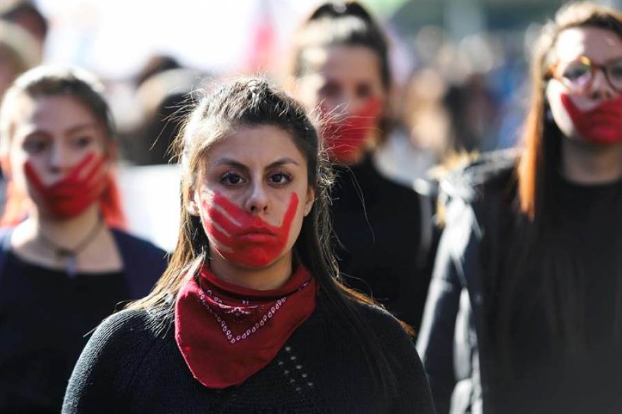 Women in Latin America protesting with red handprints on their faces