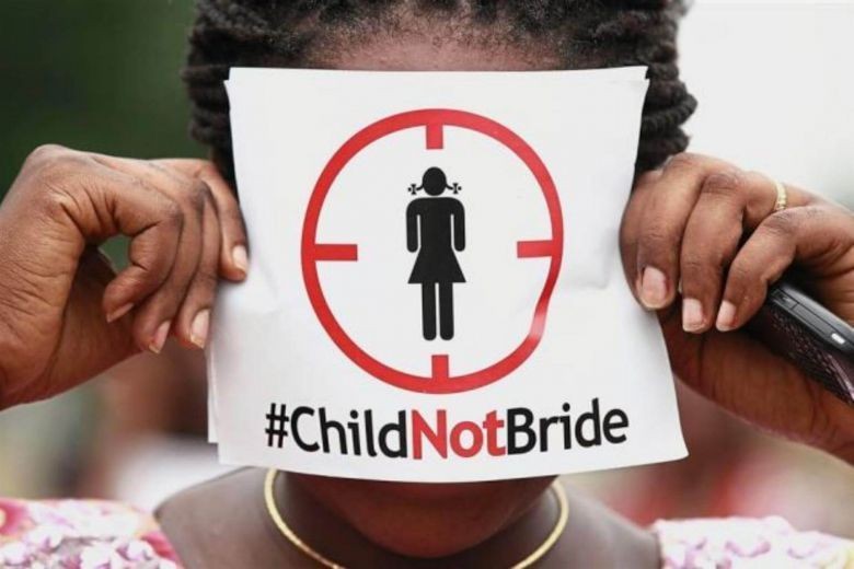 A girl holding a sign saying "Child Not Bride"