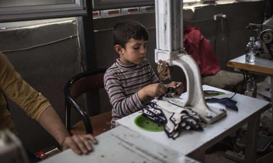A boy makes shoes in the factory