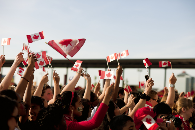 People waving Canadian flags on Canada Day