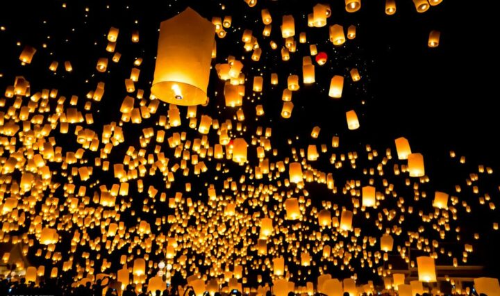 An image of lantern flying up into the night sky.