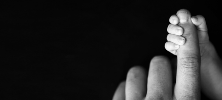 Baby holding parents finger