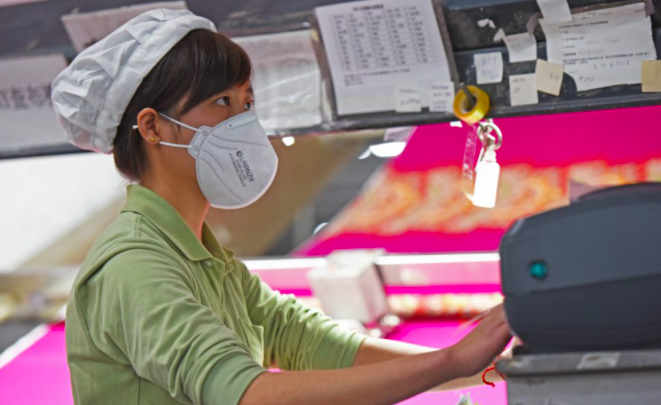 en kvindelig arbejdstager på fast fashion -fabrik i Kina