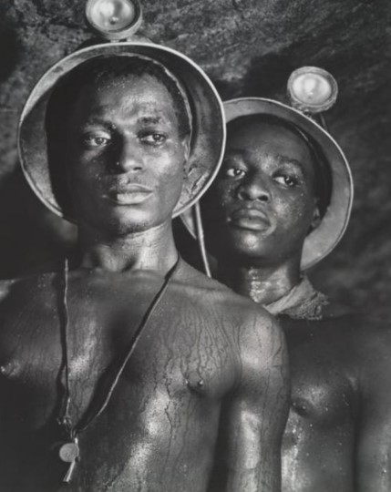 To sorte minearbejdere i sindet uden skjorter og sved på deres kroppe fra han varmer under jorden