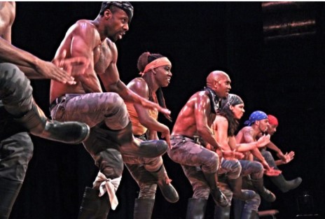 Step Afrika gumboot danicing troupe består af mænd og kvinder, der optræder på scenen