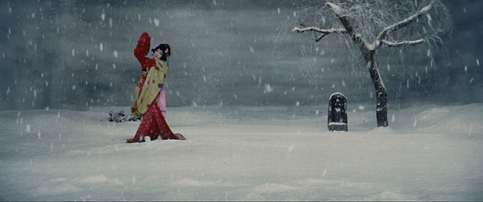 a colored picture of a kabuki actor in his red traditional Japanese dress dancing on the snow 