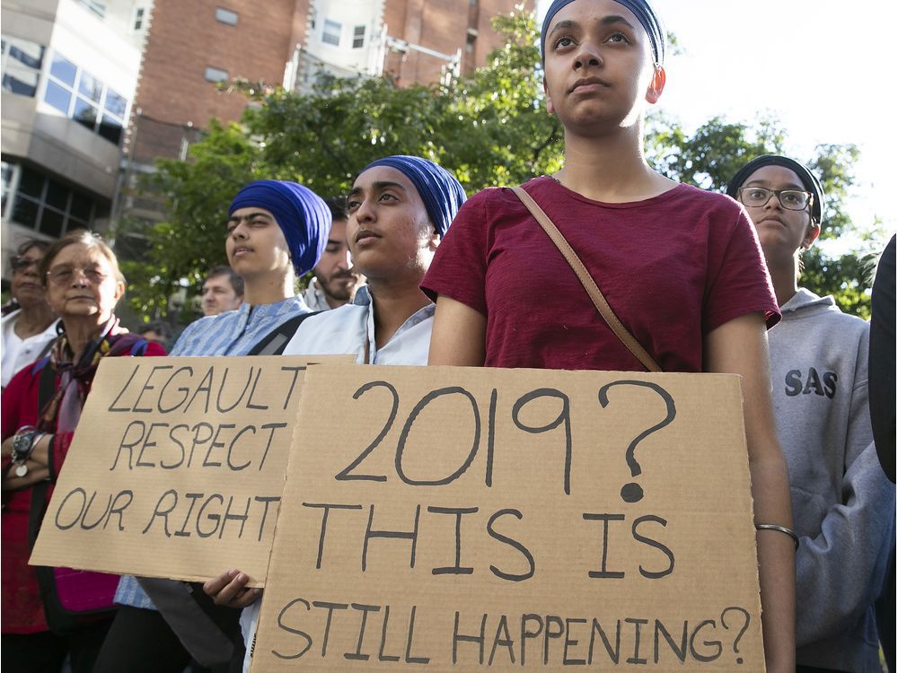 Протестиращите застават пред офиса на премиера на Квебек Франсоа Лего в центъра на Монреал на 17 юни 2019 г., за да осъдят приемането на законопроект 21.
