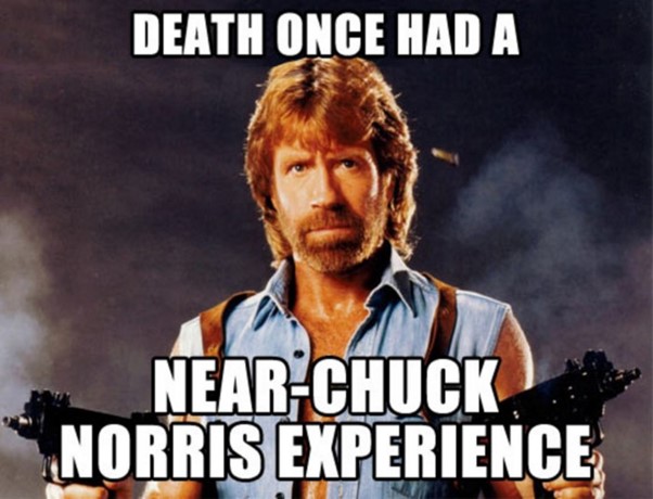 An internet meme of Chuck Norris ina cut off denim shirt a, a gun hoslter and 2 guns in his hands with a mean expression on his face with the caption