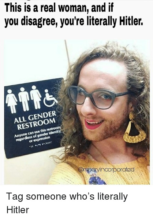 A meme of a man wearing a woman's dress, golden earrings and make up in front of a woman's restroom. he is wearing glasses and he has a beard with a smile on his face. The caption reads