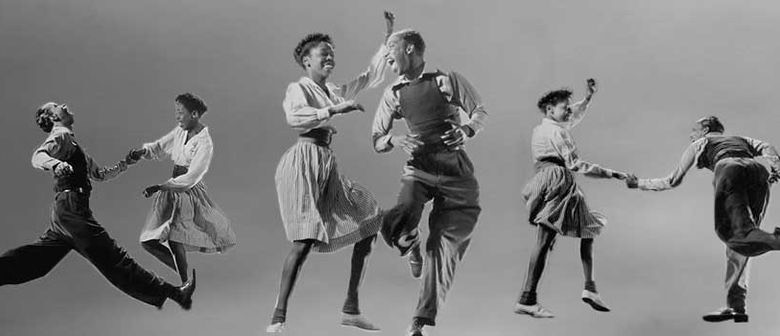sort -hvidt billede af en gruppe afrikanere, der danser Lindy Hop
