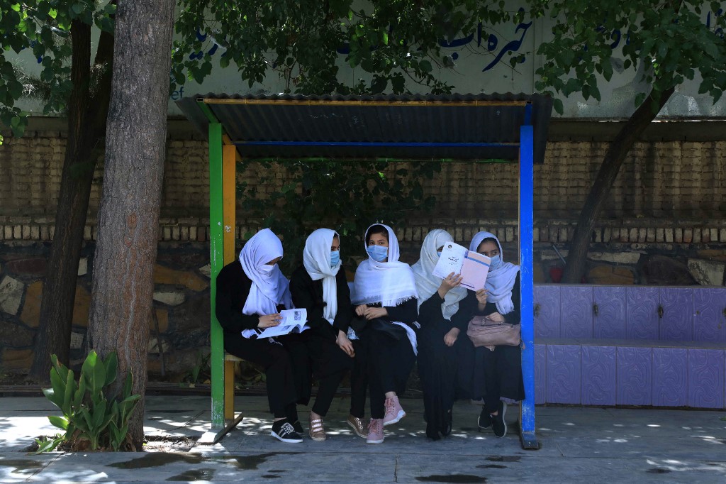 Schoolgirls sit in the schoolyard in Herat on August 17, 2021, after the Taliban's stunning takeover of the country.