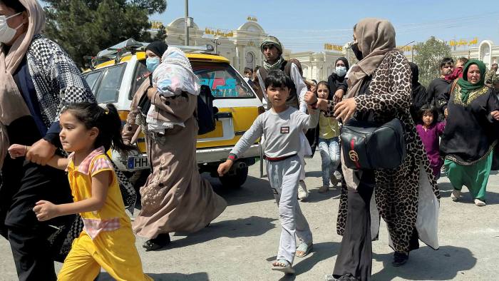 Women and children make their way to the international airport in Kabul after the Taliban takeover.