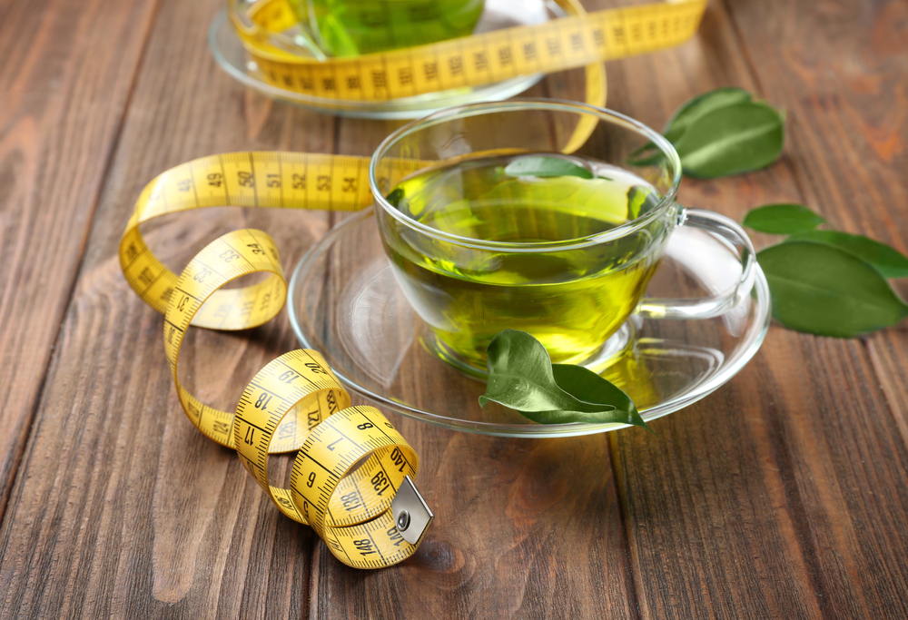 Picture of green tea and measuring tape to reveal weight loss