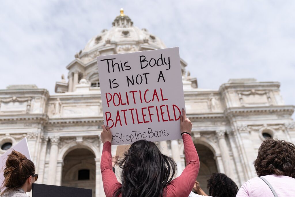 Woman holds up a sign 'this body in not a political battlefield' at a Stop Abortion Bans Rally in St Paul, Minnesota