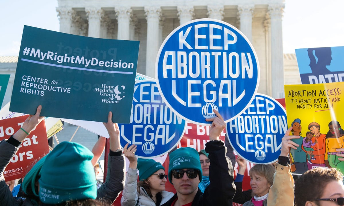 Demonstranter mod abortloven samler og holder blå skilte, der siger 'hold abort lovligt'