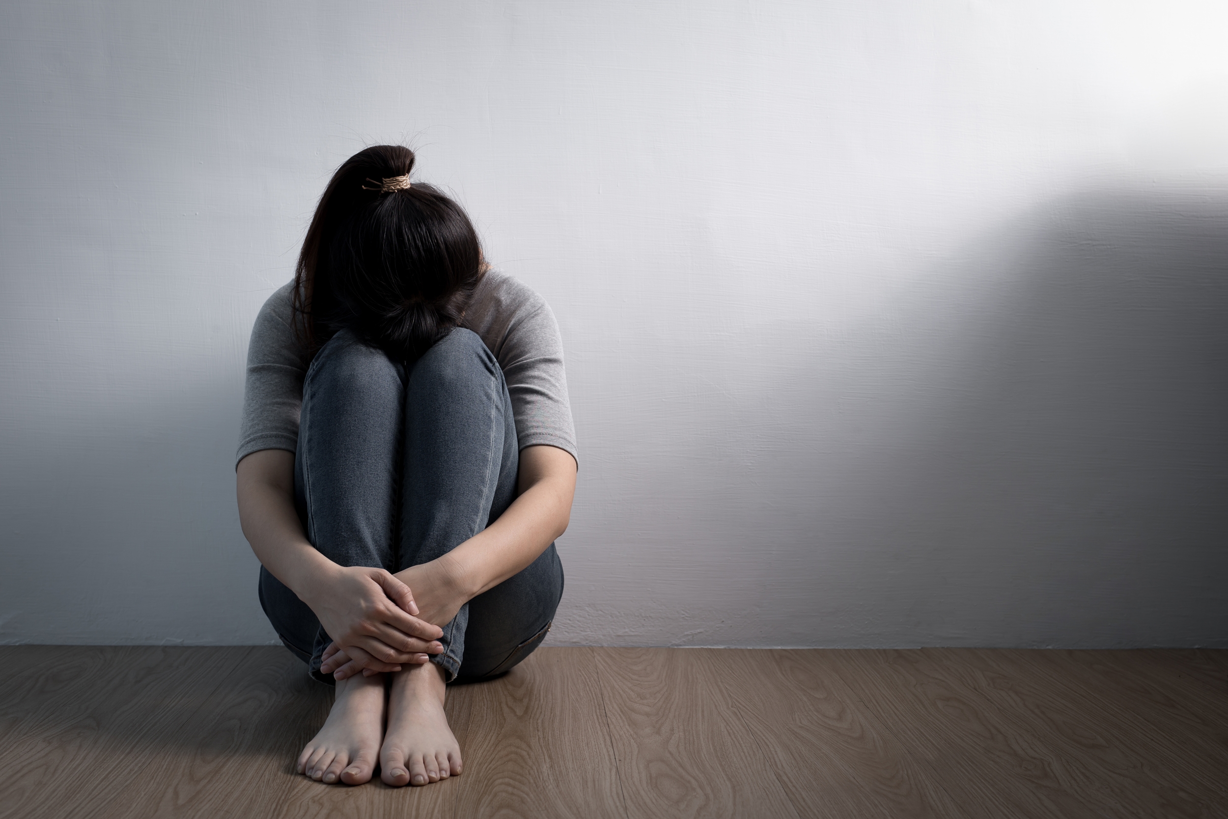 En dame, der sad på gulvet og græd på grund af depression