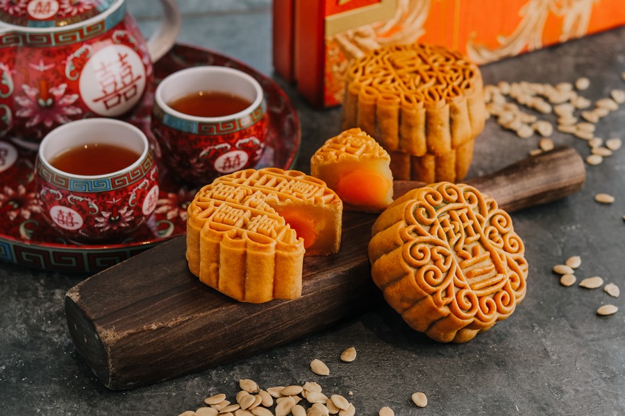 round mooncakes with salted egg yolk served with tea