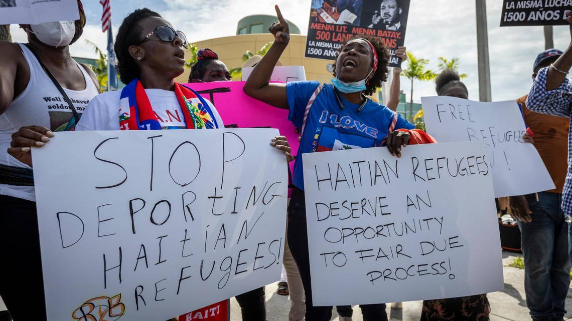 image of African women holding placards and protesting the deportations of Haitian immigrants