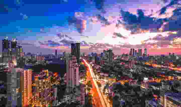 Et billede af Mumbais skyline og byens lys om natten.