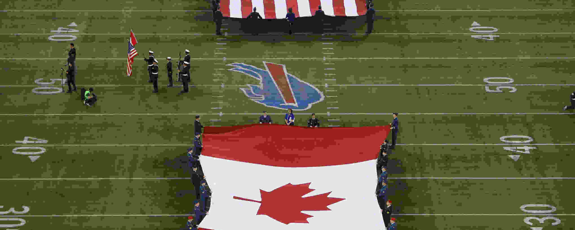 De amerikanske og canadiske flag rullede ud under et NFL -spil