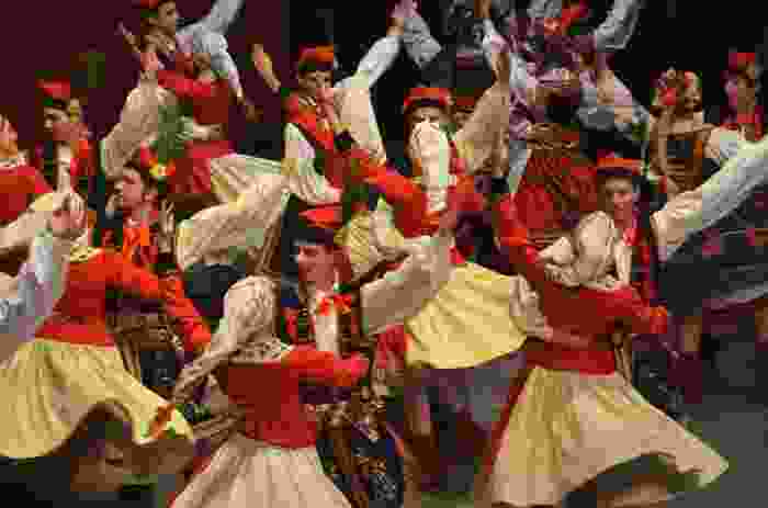 A photograph of Polish folk dancers performing the Krakowiak in traditional costumes