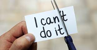 Someone is holding a page with the words "I can't do it" on it but they are cutting off the "t" so it says "I can do it".