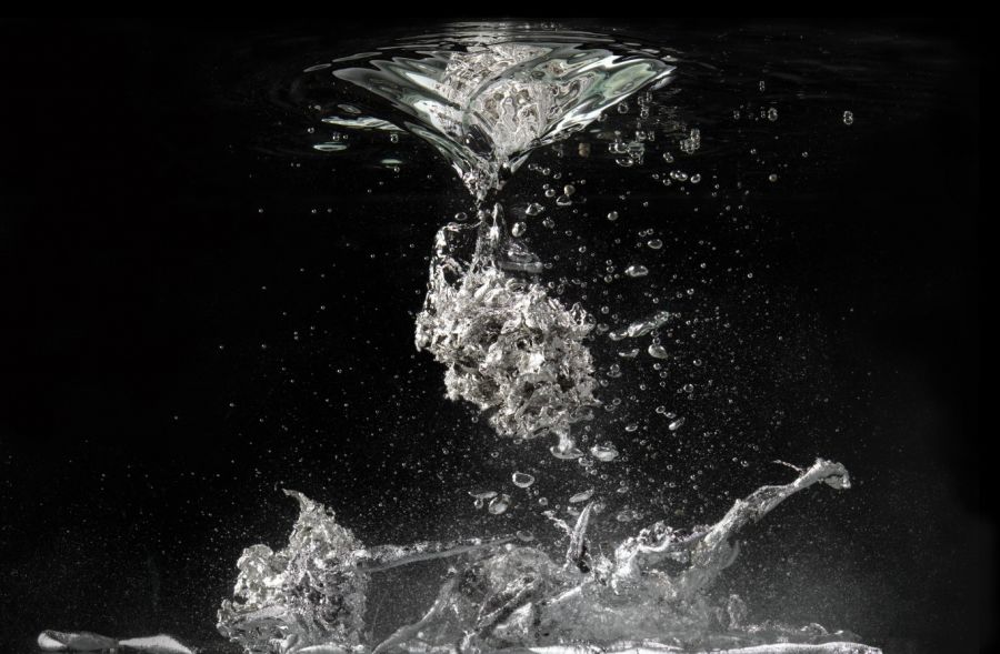 white and black image that captures the moment of molten lead falling into the cold water and forming a shape
