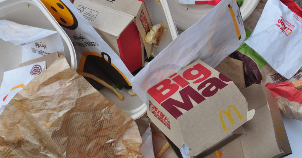 Празната опаковка на Макдоналдс разхвърляно се разпръсна на маса