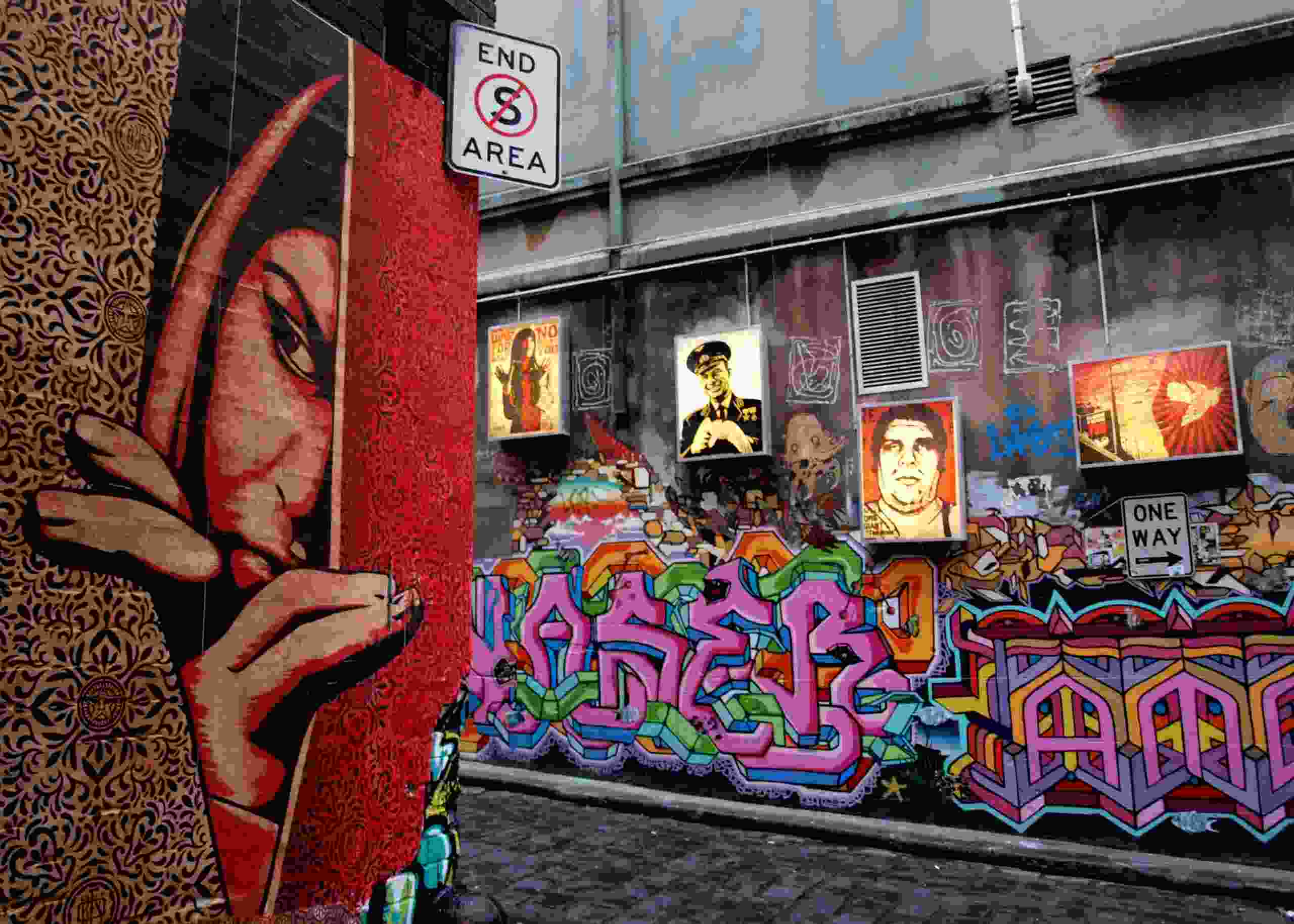 Farverig graffitibane med en malet kvinde, der kigger rundt om hjørnekanten af ​​væggen