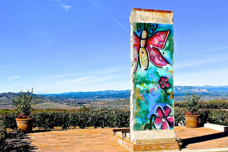 En betonstolpe dekoreret med farverig sommerfuglegraffiti