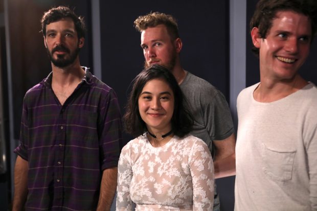 image of Japanese Breakfast band members, as the front-woman sits other male members are standing behind her