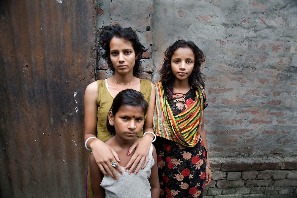 An image of a sex works at age 17, 14, and eight, who are sex workers in the red-light district of Bangladesh.