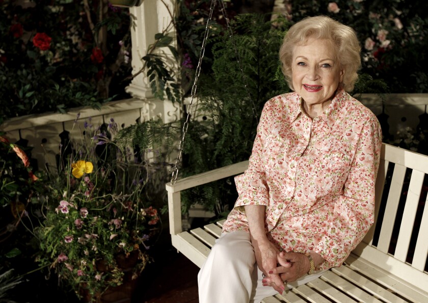 Actress Betty White sitting on a patio