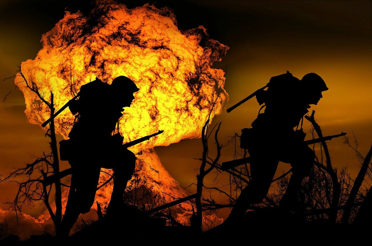 soldiers walking in front og an explosion