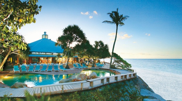 Heron Island resort sits on the shoreline of the island with a swimming pool at sunset, an ideal spot for a holiday.
