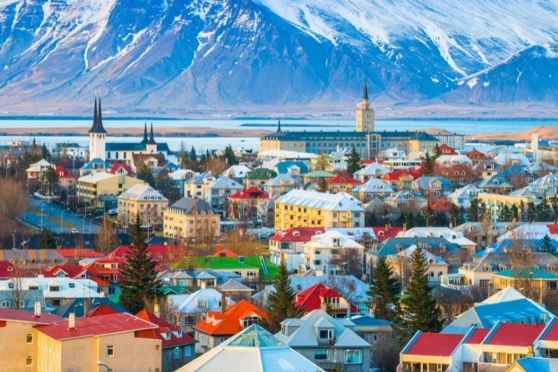 En udsigt over reykjavik med sine farverige huse og bjerge.