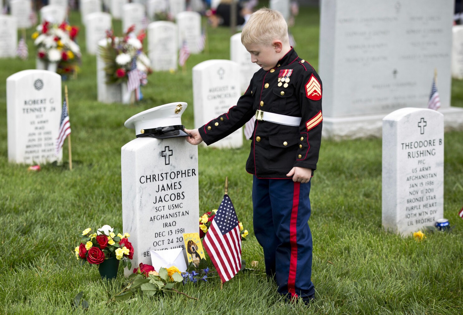 child decorating the grave of a fallen soldier