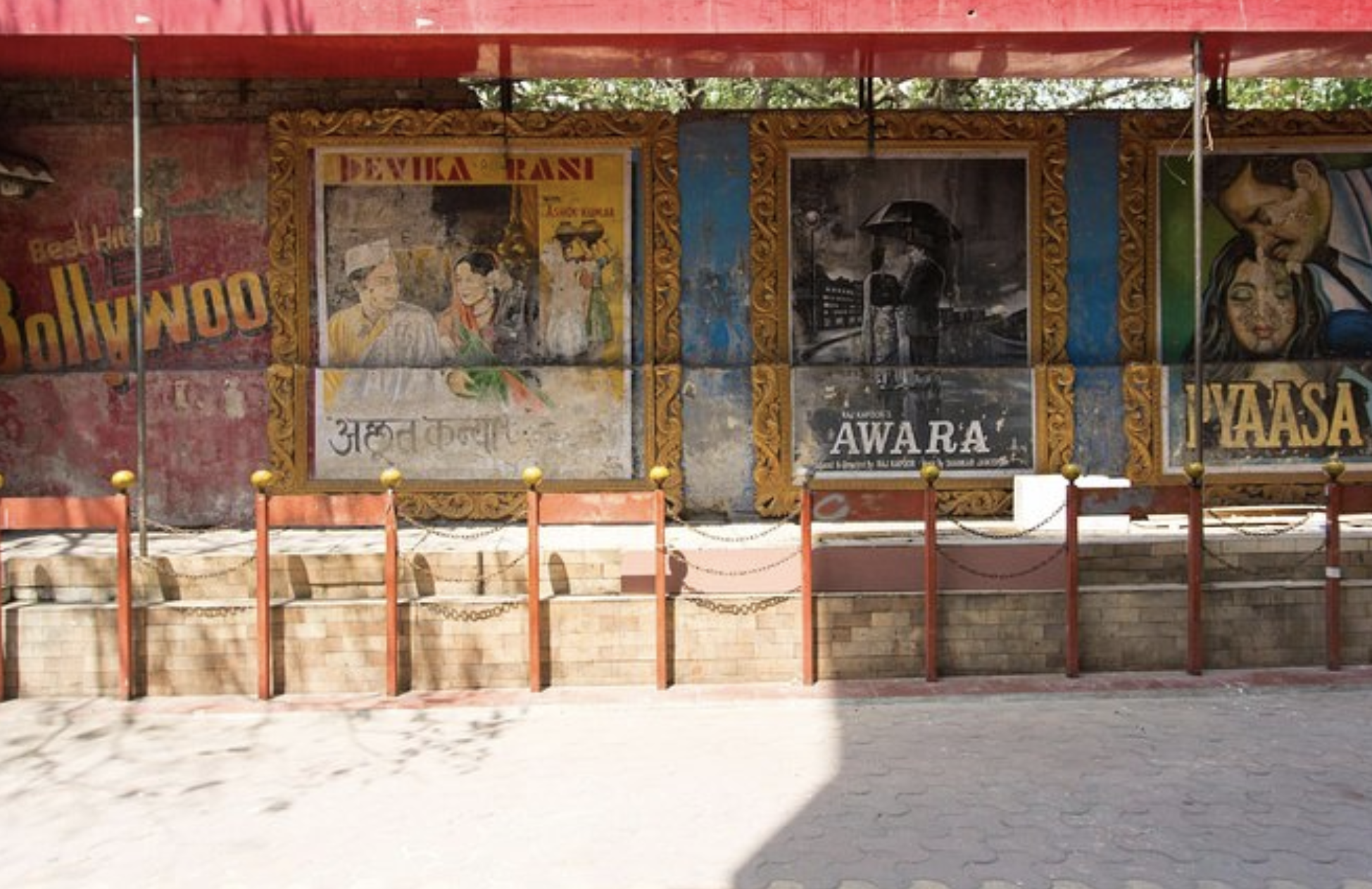 Strada comună din India. Afișe Bollywood care decorează pereții de-a lungul trotuarelor.